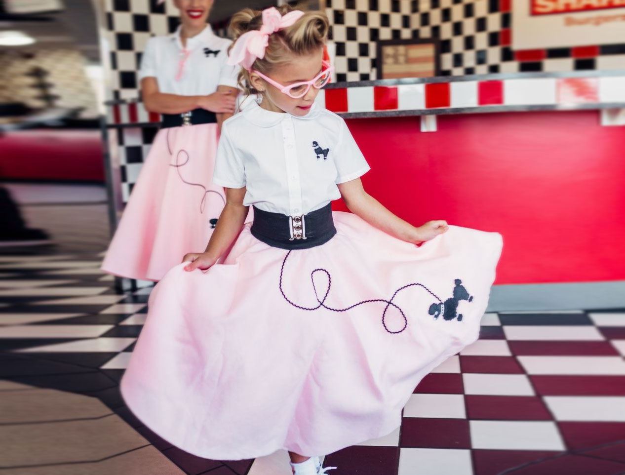 toddler wearing white and pink vintage 50's poodle skirt